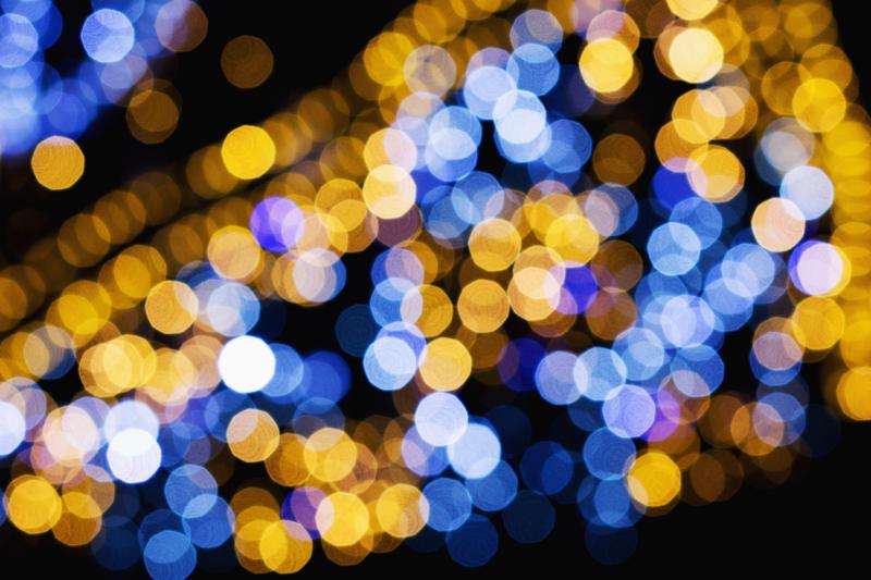 An abstract image of blue, gold and white lights in a dark sky