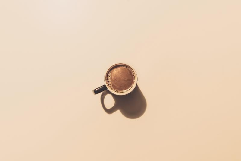 Aerial view of coffee in a mug on a beige background